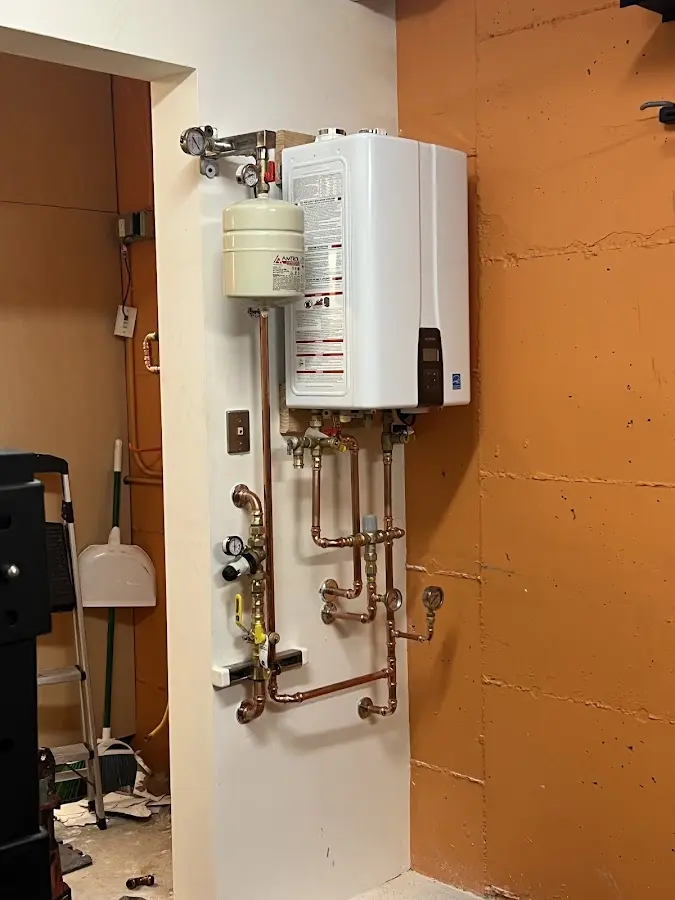 Plumbing technician inspecting water heater connections in Prairie du Sac